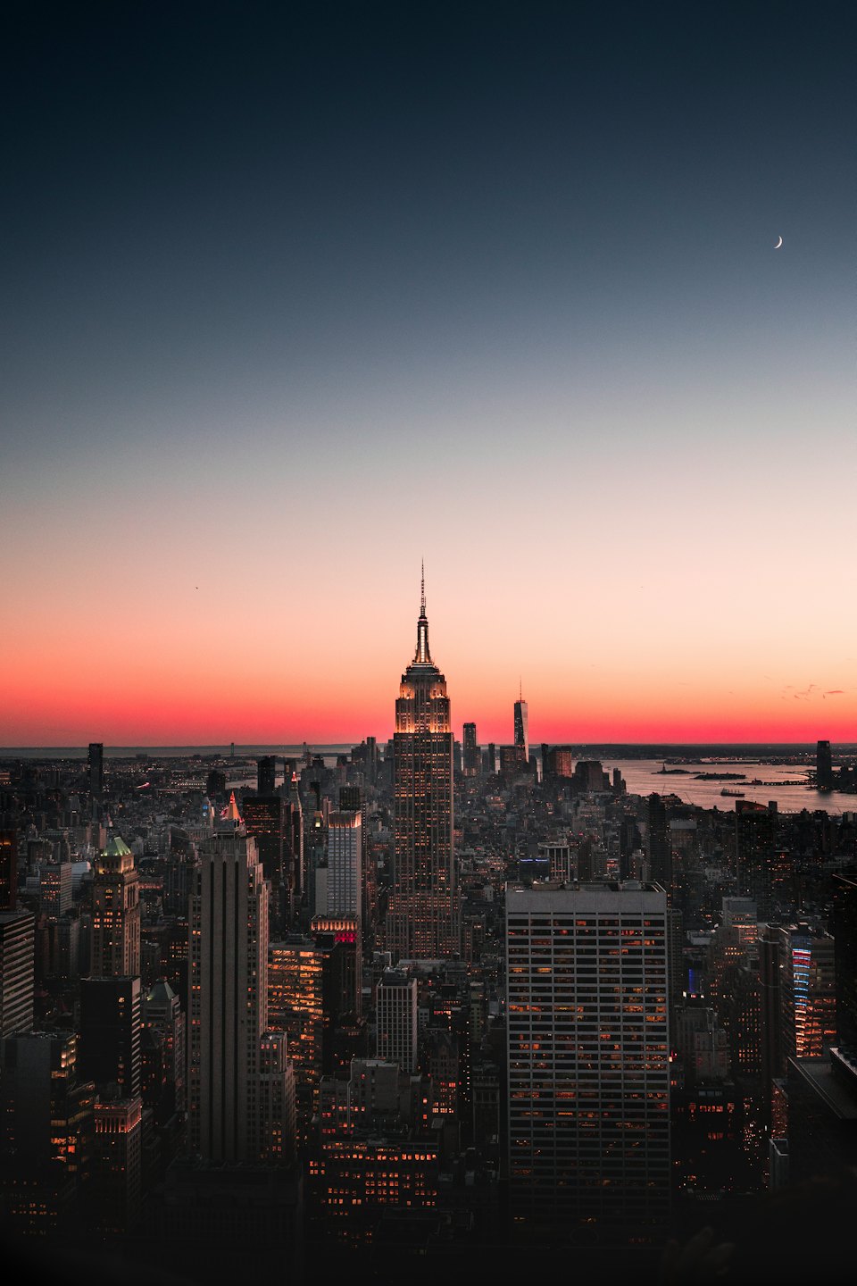 City skyline at twilight with the Empire State Building illuminated.