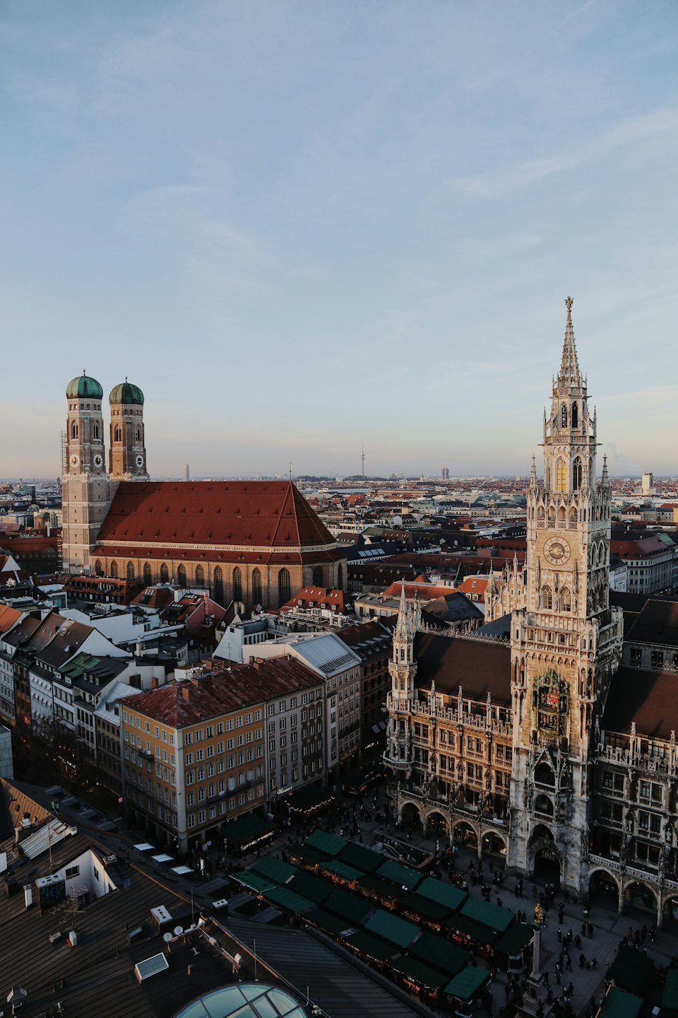 Historic European city buildings with market stalls and people below.