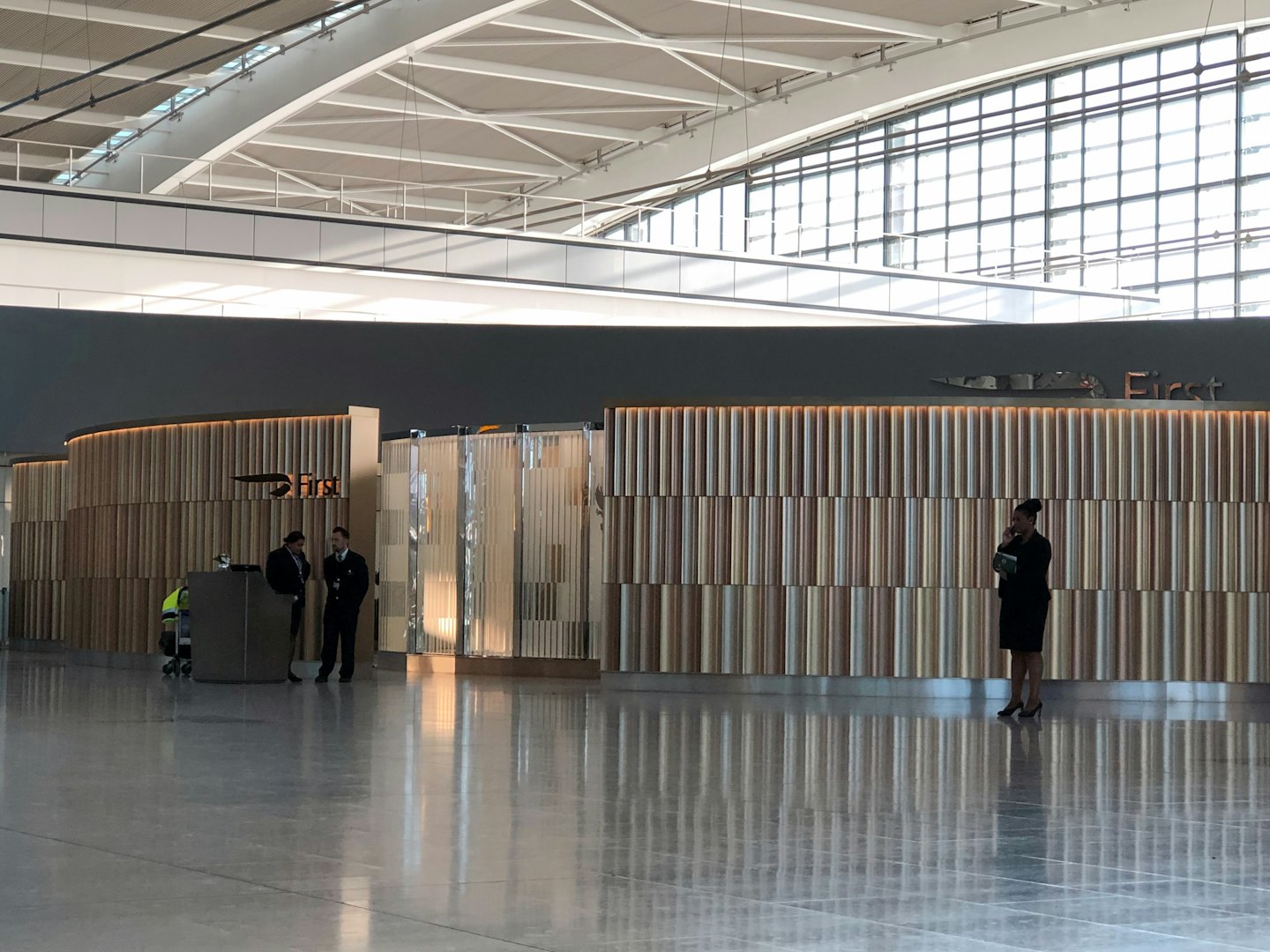 Airline staff at a check-in desk in a bright airport terminal.