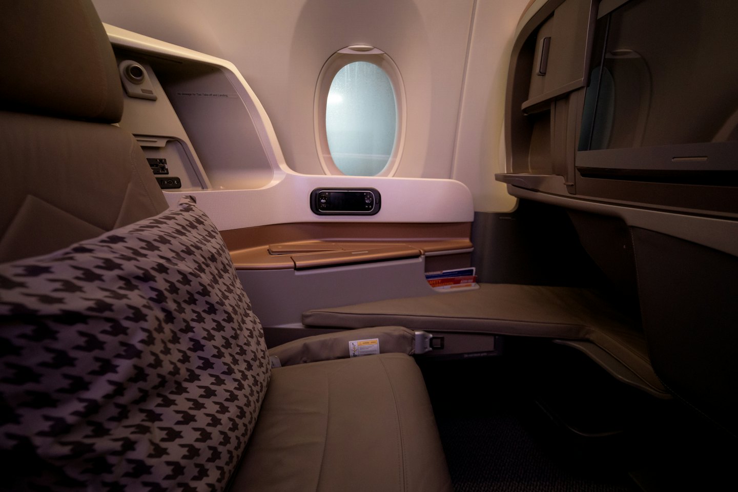 Luxurious airplane seat with a comfortable brown leather seat and pillow.